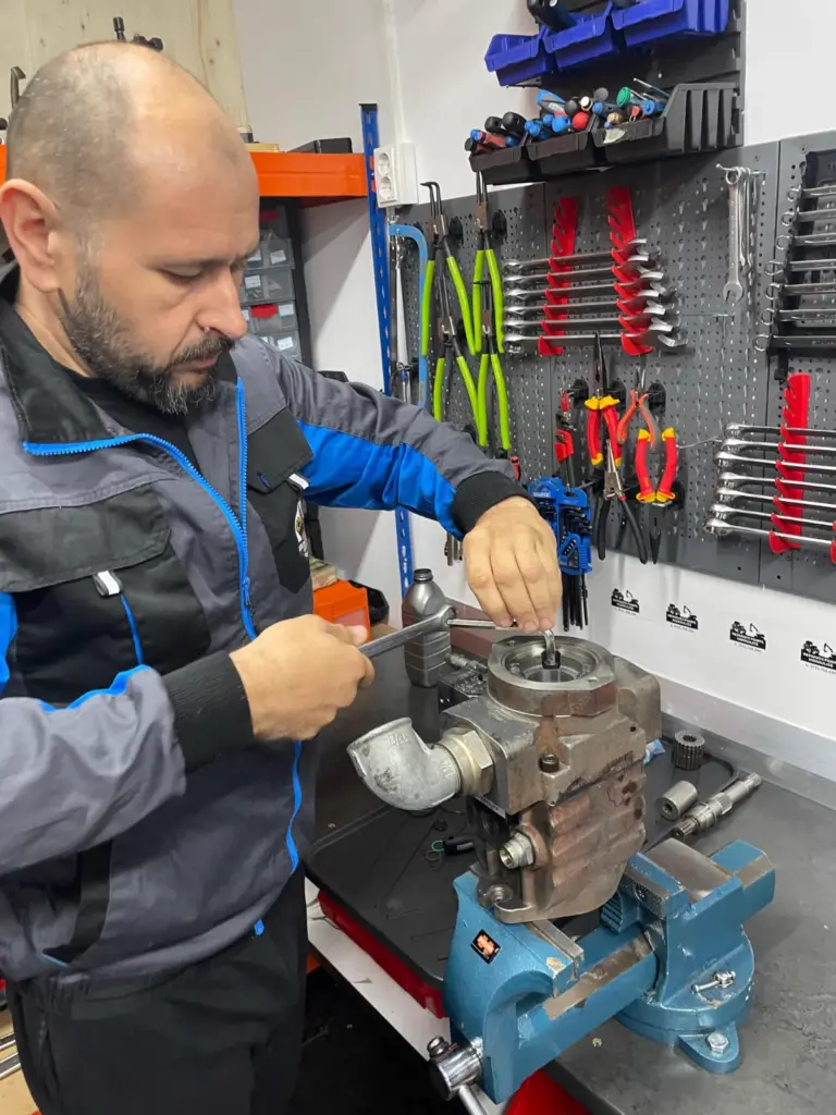Costică repară o pompă hidraulică în atelier